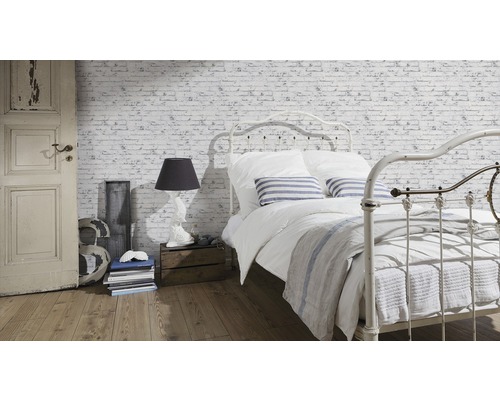 Helles Schlafzimmer mit Bett vor Ziegelwandtapete