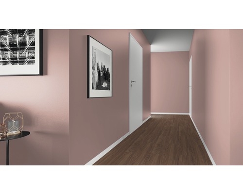 Couloir avec murs peints en rose, plancher en bois foncé et portes blanches