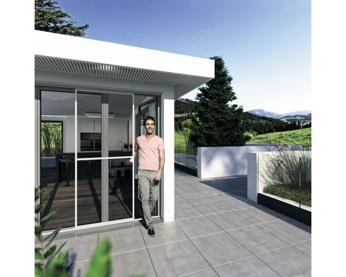 Homme entrant dans une maison moderne avec porte coulissante et terrasse