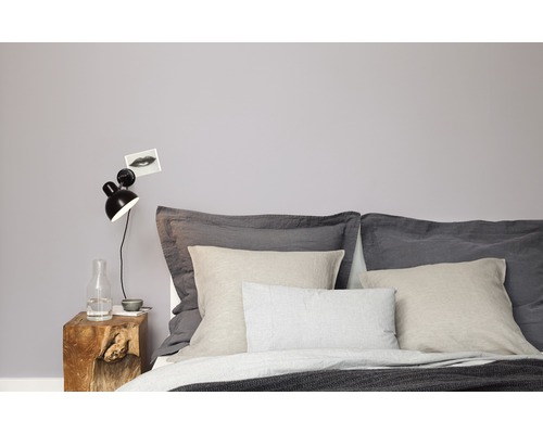 Chambre avec lit, coussins, table de chevet en bois et lampe