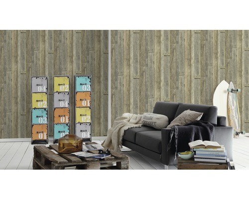 Salon avec papier peint lambris bois, canapé noir, planche de surf et armoires colorées