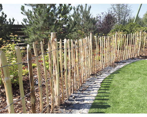 Clôture en bois dans le jardin avec pelouse et plantes