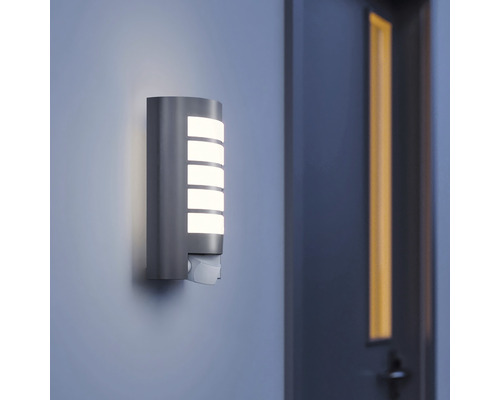 Leuchtende Aussenwandleuchte mit Bewegungsmelder an einer Wand