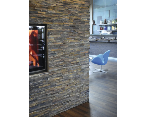 Mur avec parement en pierre naturelle et cheminée dans le salon.