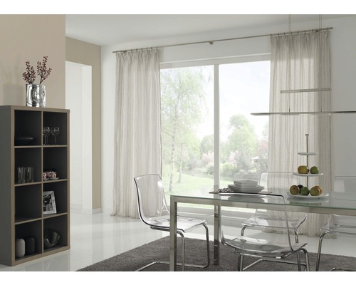 Helles Esszimmer mit Esstisch, transparenten Stühlen, Regal und Vorhängen