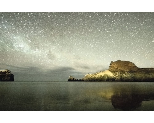 Sternenhimmel über Felsen am Meer