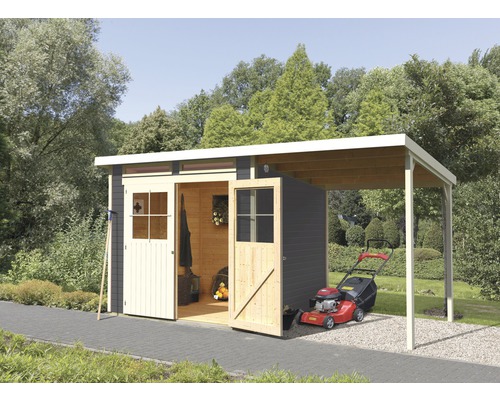 Abri de jardin en bois avec annexe et tondeuse à gazon dans le jardin