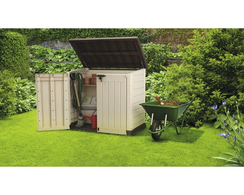 Gartenschrank mit geöffneten Türen, gefüllt mit Gartengeräten, neben einer Schubkarre im Garten