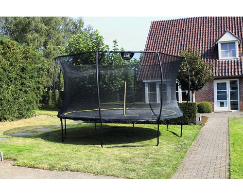 Scène de jardin avec trampoline et filet de sécurité à l''extérieur.