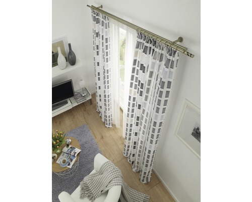 Wohnzimmer mit Vorhängen mit geometrischem Muster und zweiläufiger Vorhangstange