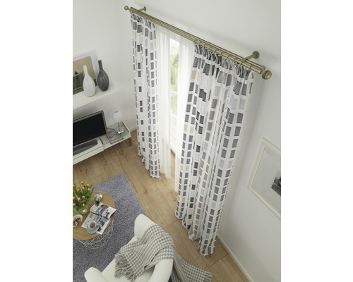 Salon avec rideaux et tentures à motifs géométriques sur une tringle à rideaux