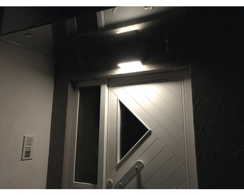 Zone d''entrée de maison éclairée avec porte et sonnette