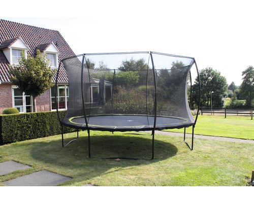 Trampoline de jardin rond avec filet de sécurité sur une pelouse