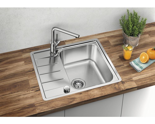 Évier en acier inoxydable avec égouttoir et robinet sur un plan de travail en bois