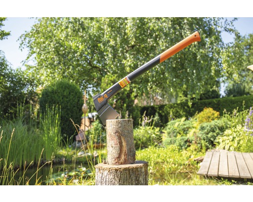 Hache à fendre dans une bûche d''arbre dans le jardin