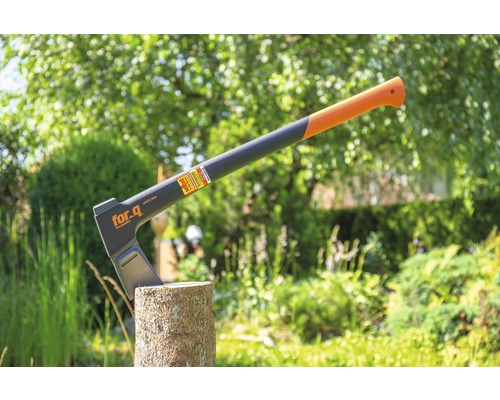 Hache sur une souche d''arbre dans le jardin