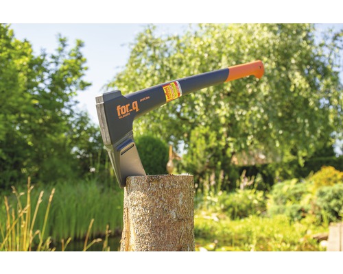 Hache à fendre sur une bûche dans le jardin avec le logo For_q.