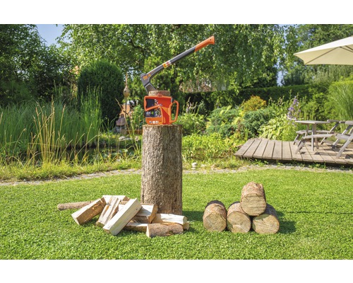 Hache à fendre avec coin à fendre sur une bûche dans le jardin avec du bois de chauffage.