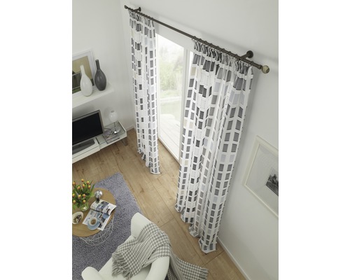 Wohnzimmer mit Vorhängen mit geometrischem Muster vor einem Fenster