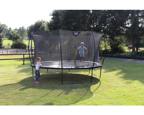 Aufnahme eines Gartentrampolins mit Sicherheitsnetz, auf dem ein Kind springt und ein anderes steht.