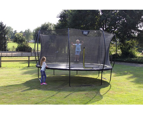 Kind springt auf Gartentrampolin mit Sicherheitsnetz