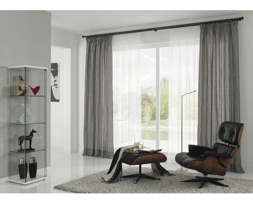 Salon avec rideaux, fauteuil, tapis et vitrine