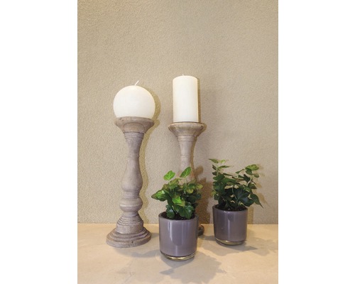 Dekorative Szene mit Kerzen auf Kerzenständern und Zimmerpflanzen in Töpfen