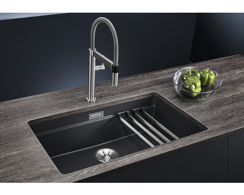 Spüle mit Armatur und Abtropfgestell auf einer Arbeitsplatte.