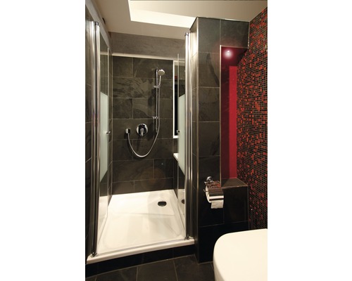 Badezimmer mit Dusche, Toilette und dunklen Fliesen