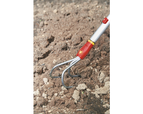 Wolf Garten Logo. Dreizack-Bodenkrümler im Erdreich.