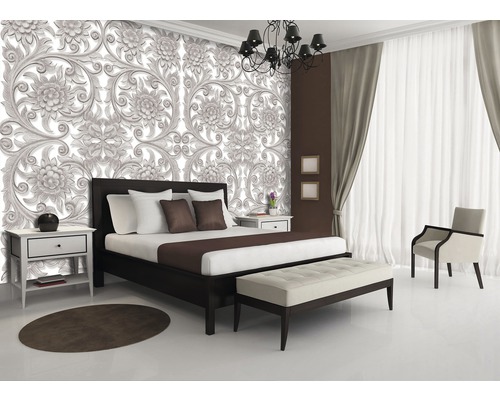 Schlafzimmer mit Bett, Nachttisch und floraler Tapete