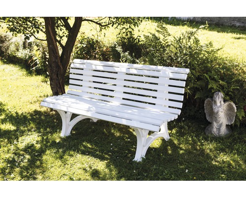 Banc de jardin blanc en bois avec statue dans le jardin.