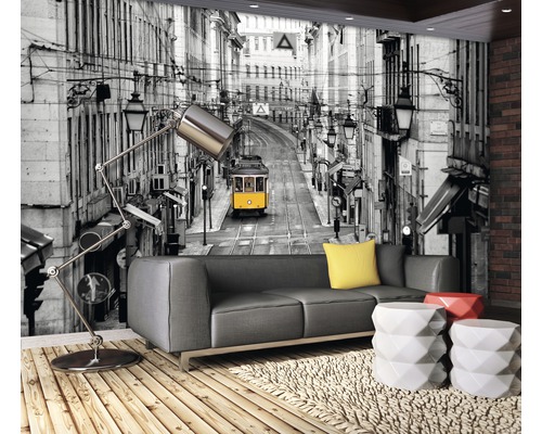 Salon avec canapé gris, tables d''appoint et papier peint photo avec motif de rue