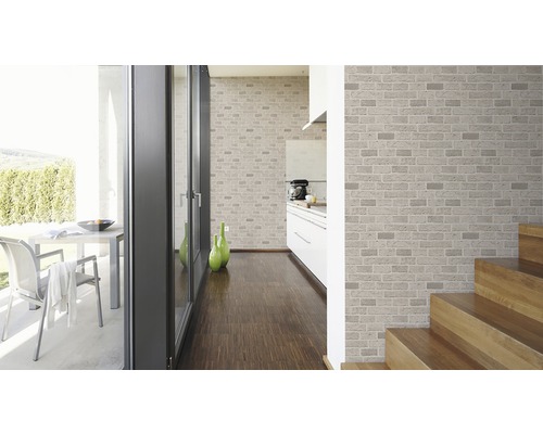 Espace de vie lumineux avec papier peint brique, parquet et escalier