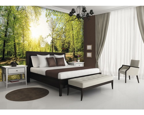 Helles Schlafzimmer mit Waldtapete, Bett, Nachttisch und Stuhl