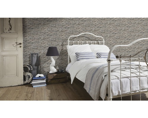 Chambre décorative avec papier peint aspect pierre, lit et lampe