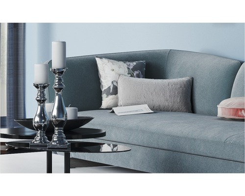 Wohnzimmer mit Sofa, Kissen und Kerzenständern auf einem Tisch