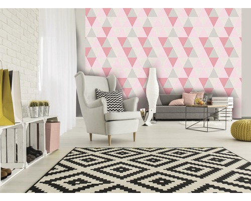 Salon avec fauteuil, canapé et papier peint géométrique à motifs de triangles