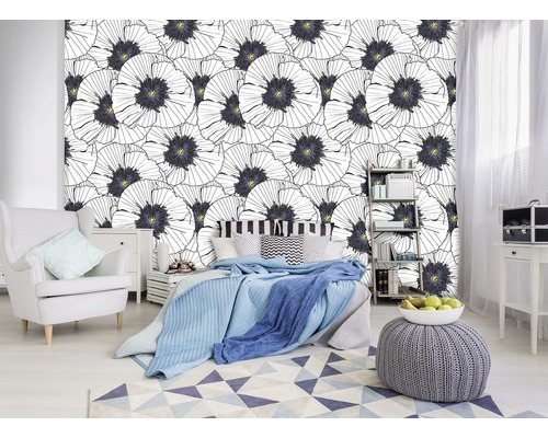 Chambre à coucher avec papier peint photo à motif floral, lit et fauteuil.