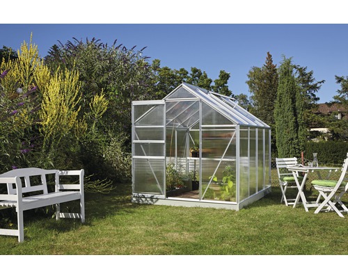 Gewächshaus Vitavia Comet 5000 Hohlkammerplatten 4 mm 195x257 cm Aluminium Gewächshaus im Garten mit geöffneter Tür, Gartenmöbeln und Bepflanzung