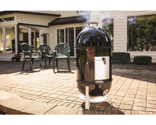 Schwarzer Watersmoker Grill mit silberner Tür auf einer Terrasse