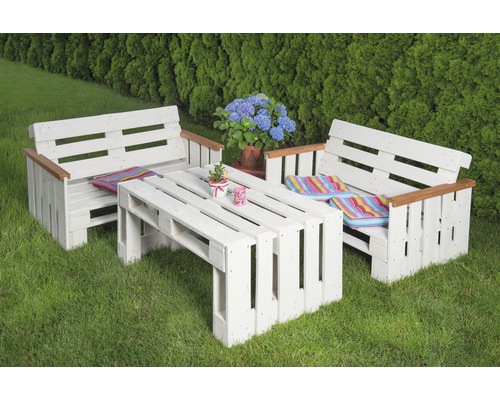 Ensemble de meubles de jardin en palettes avec deux bancs et une table sur une pelouse