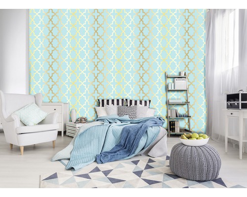 Schlafzimmer mit Bett, Sessel und Wandtapete mit Muster