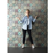 Frau steht vor einer Wand mit Fliesenmuster Tapete