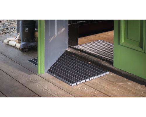 Espace d''entrée avec paillasson, porte et plancher en bois