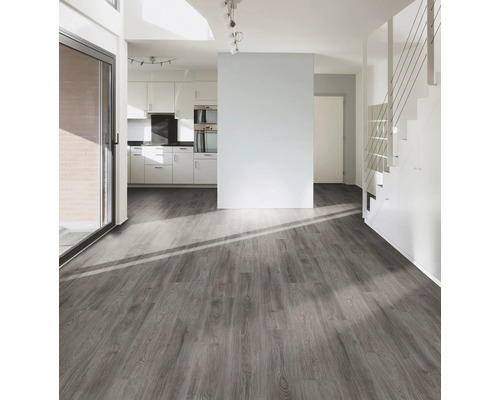 Salon lumineux avec plancher en bois gris, escalier et kitchenette