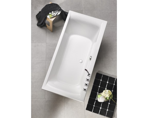 Aufnahme von oben einer Badewanne im Badezimmer mit Armaturen und Badematte