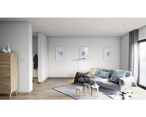 Salon lumineux avec canapé, tapis, commode en bois et tableaux muraux.