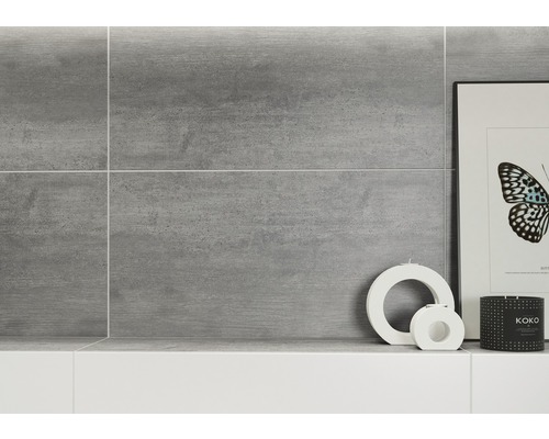 Mur de carreaux gris dans salle de bains avec éléments décoratifs
