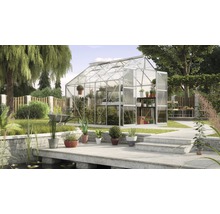Gewächshaus mit Pflanzenregalen in einem Garten mit Teich